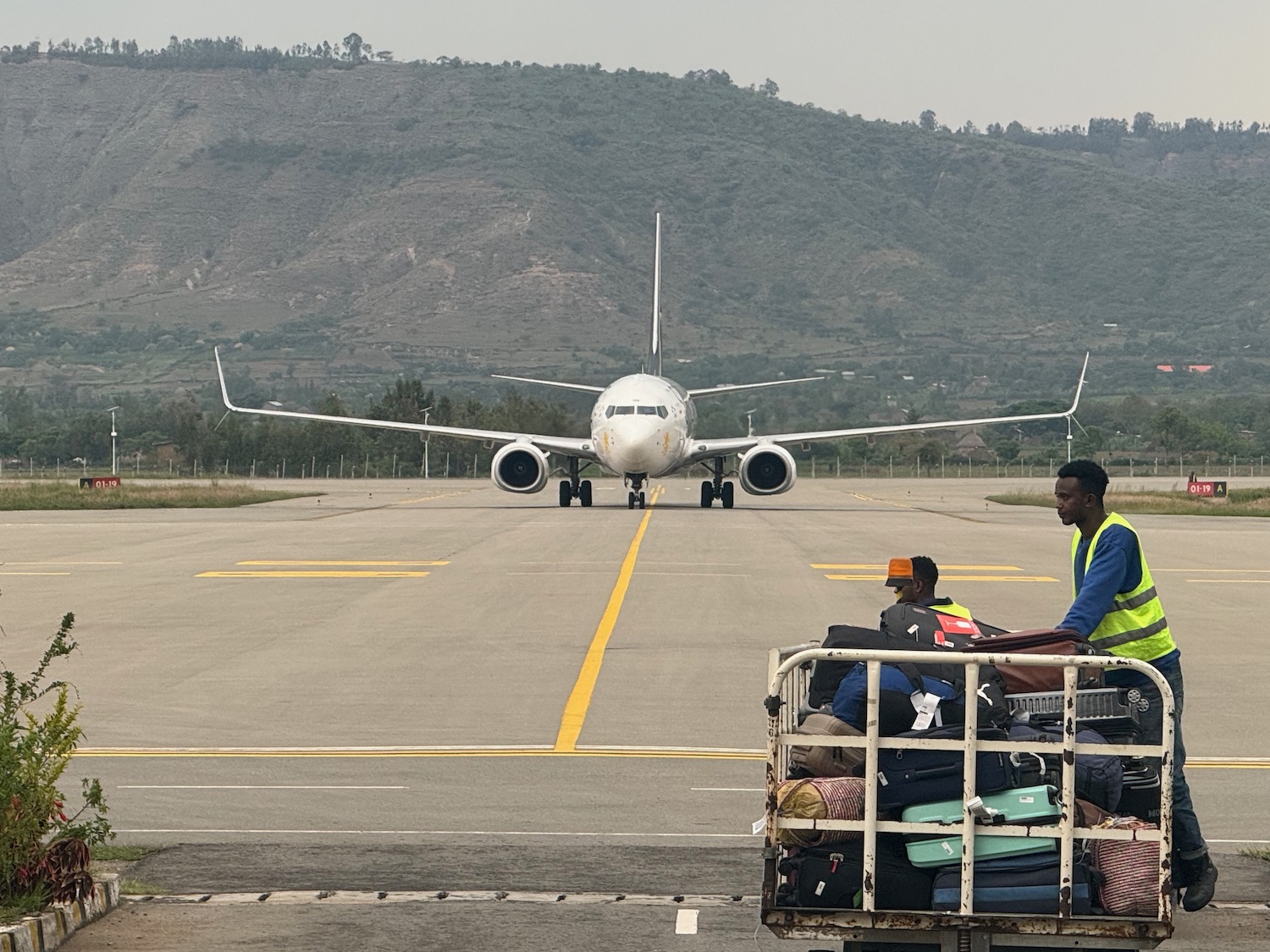 a group of people sitting on a runway with a large white airplane