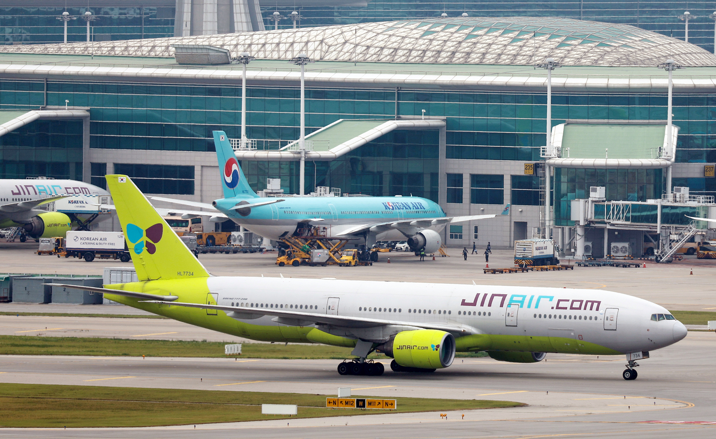 Jin Air and Korean Air planes sit on the tarmac at Incheon International Airport on July 13. [YONHAP]