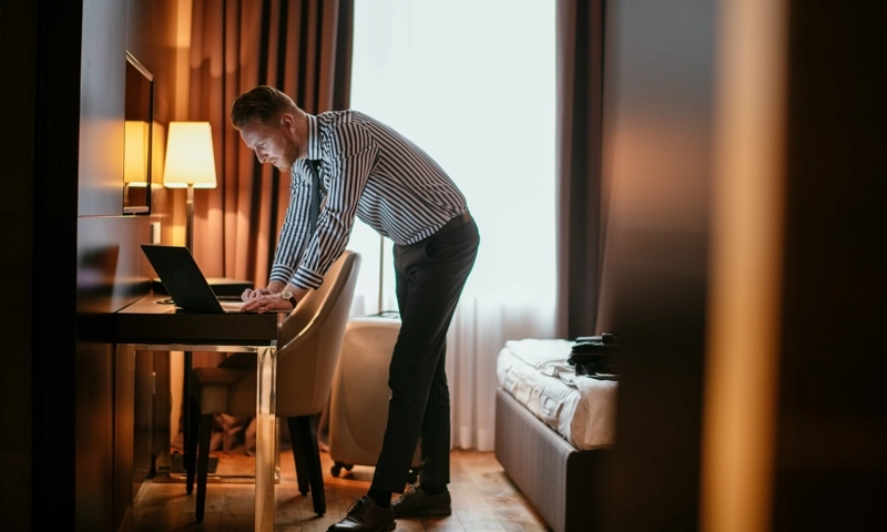 A man using a computer in a hotel room