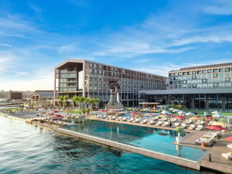 Waterfront hotel complex at Tersane Istanbul with outdoor pool, sun loungers and modern buildings overlooking the Golden Horn.