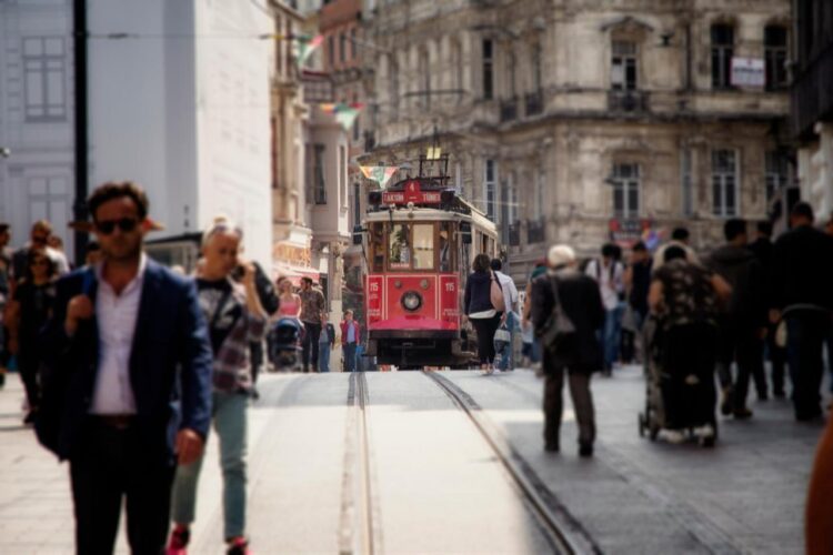 A red tram travels along Istiklal Avenue near Taksim Square in Istanbul, Türkiye, May 2, 2018. (Adobe Stock Photo)