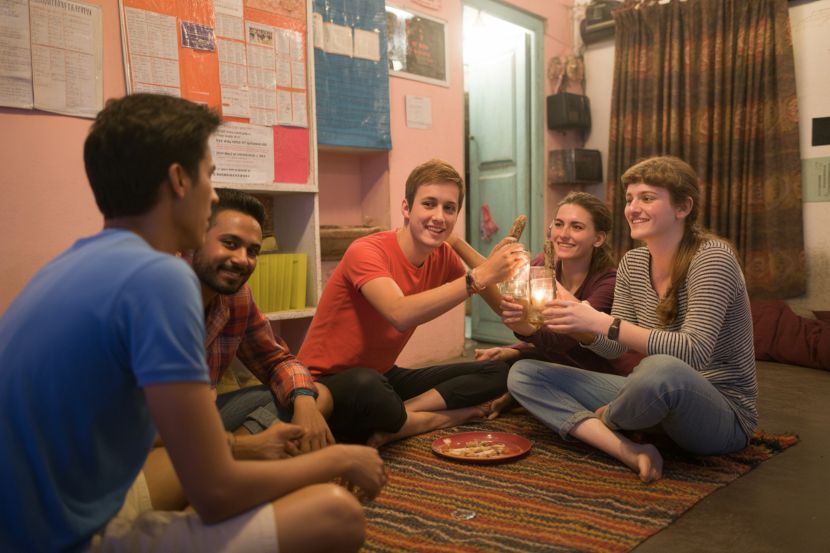 Young travellers bond over shared experiences and stories at an indian hostel during winter.
