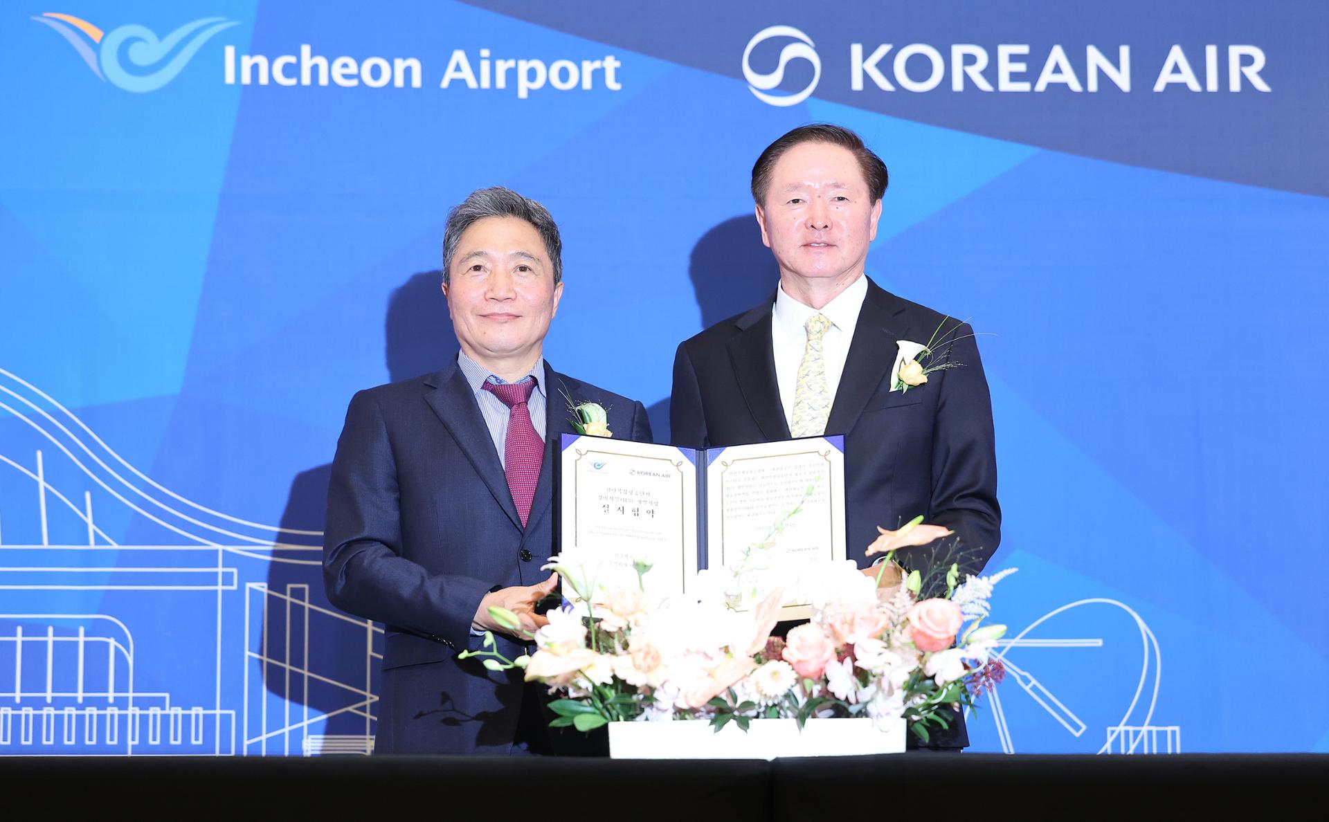 This photo provided by Korean Air  shows Vice Chairman Woo Kee-hong, right, and Lee Hak-jae, president and chief executive officer of Incheon International Airport, at an agreement signing ceremony at a hotel in Incheon, Monday, to build a joint maintenance hangar at the airport located west of Seoul. Yonhap