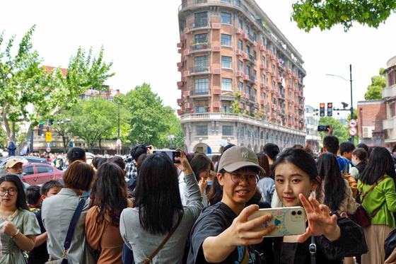 Tourists take pictures in front of the Wukang Mansion in Shanghai, China [XINHUA NEWS AGENCY]