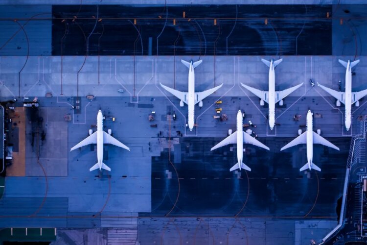 Overhead view of planes on a tarmac with a blue background.