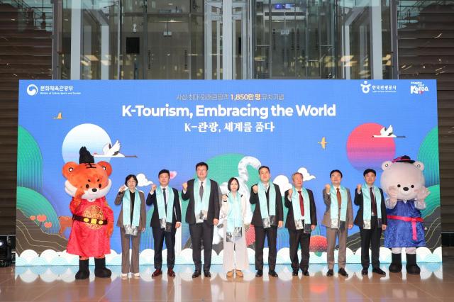 Kim Dae Hyun, fourth from left, second vice minister of culture, sports and tourism, and Seo Young Choong, sixth from left, acting president of the Korea Tourism Organization, pose with Charmaine Lee of Singapore, fifth from left, the 18.5 millionth visitor to South Korea, during a ceremony at Incheon International Airport Terminal 2. Photo: Korea Tourism Organization