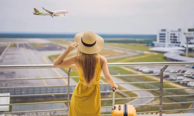 A woman at an airport watching an airplane land