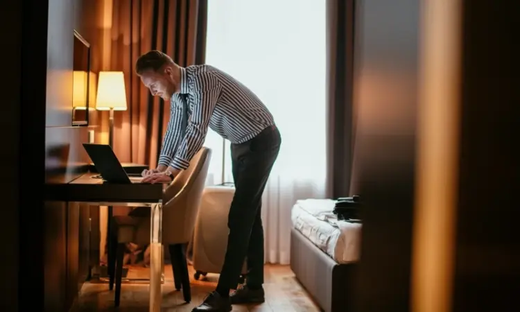 A man using a computer in a hotel room