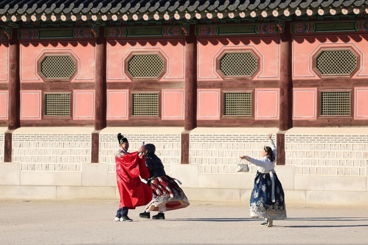 International tourists dressed in Hanbok take photos in front of Gyeongbok Palace in central Seoul, Jan. 1. Newsis