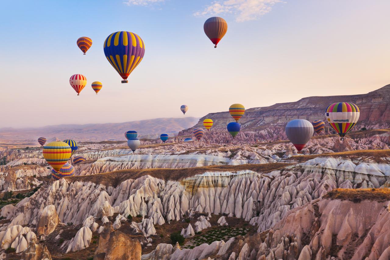 Hot air balloons fly over Cappadocia, Türkiye. (Adobe Stock Photo)