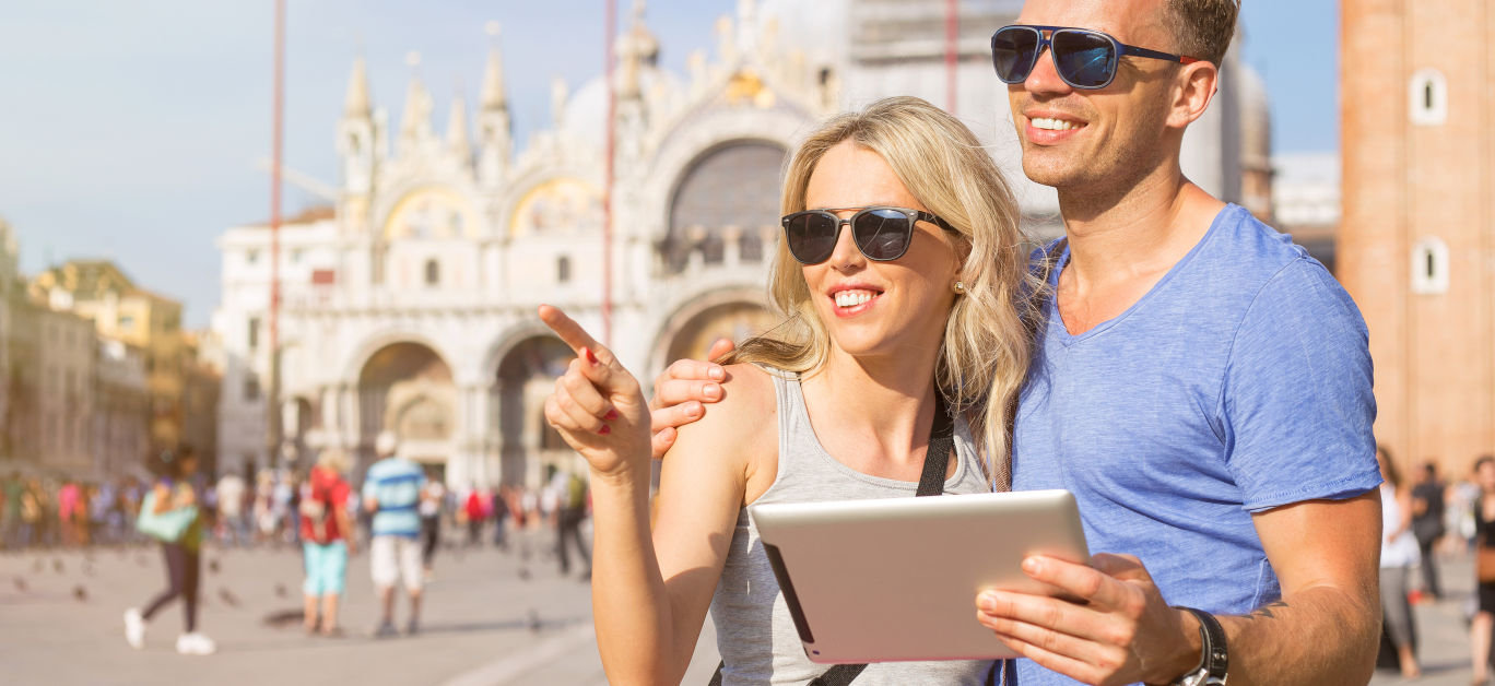 Young tourists using tablet computer while traveling