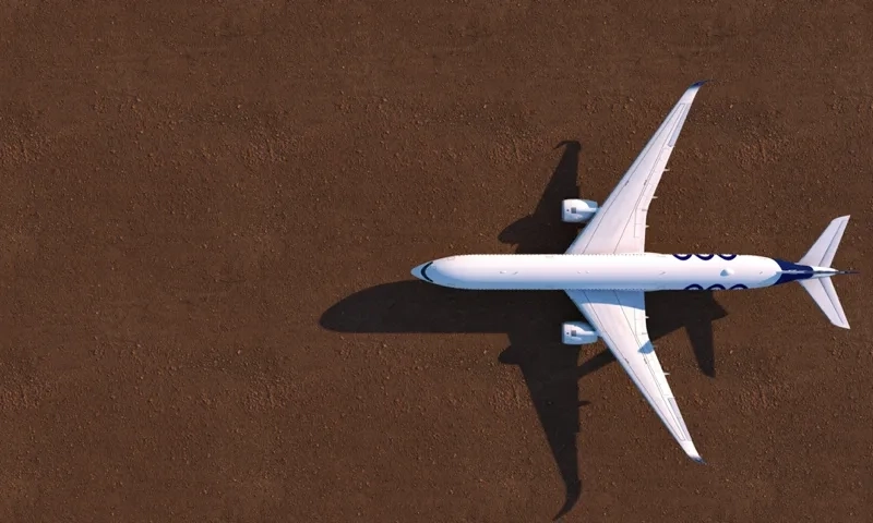 A white airplane flying over a brown ground