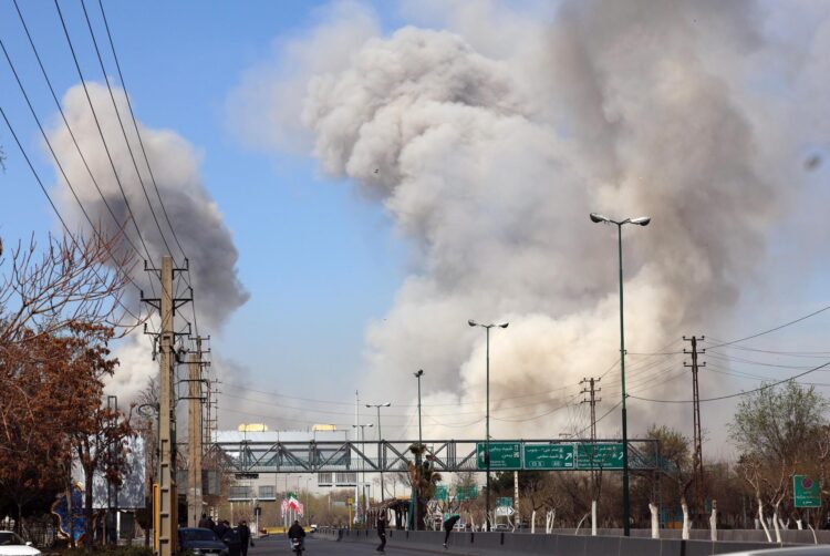 People run for safety as smoke rises after an airstrike in central Tehran, Iran, March 5. EPA-Yonhap