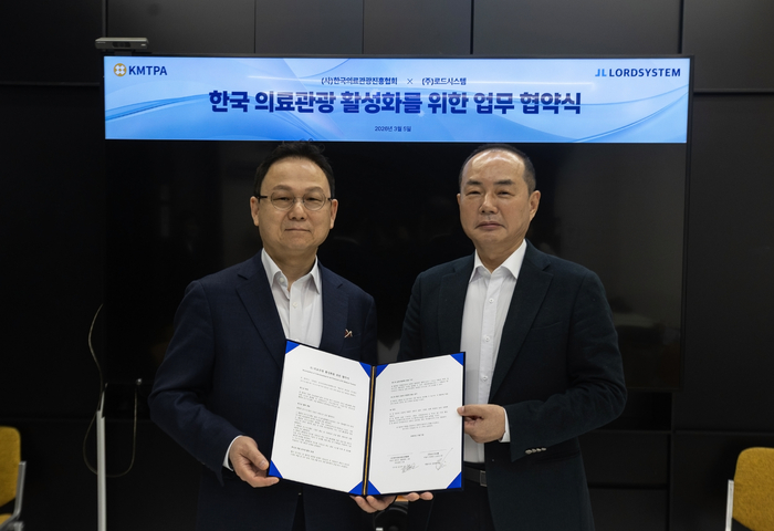 Jang Yang-ho, CEO of Road System (left), and Kim Jin-guk, chairman of the Korea Medical Tourism Promotion Association, are signing a business agreement.