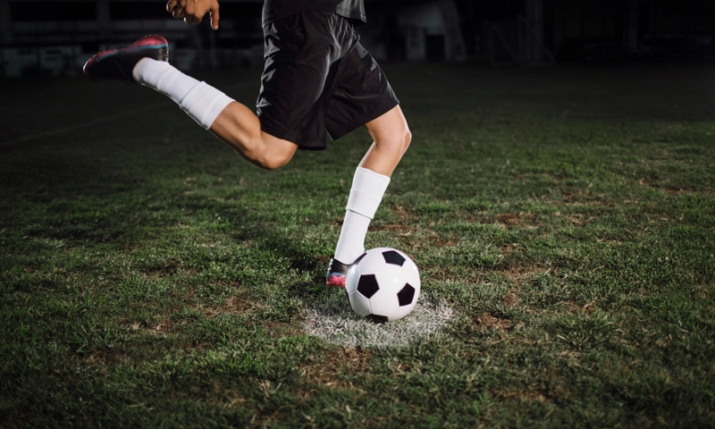 A player kicking a soccer ball