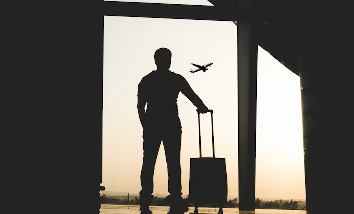 A silhouette of a passenger with his recovered suitcase