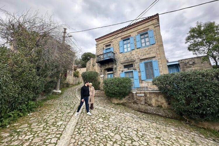 A view of a traditional stone house with blue shutters along a narrow street in Adatepe village, Canakkale, Türkiye. (AA Photo)