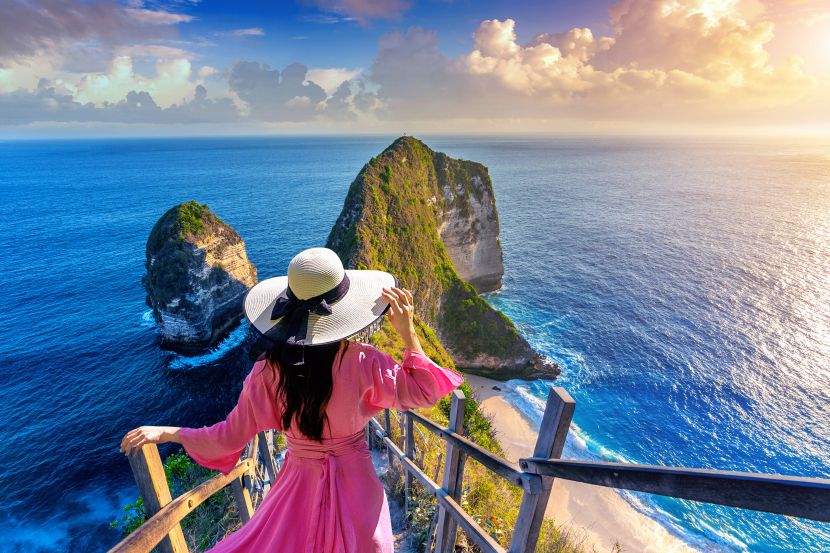 Woman overlooking ocean view at scenic coastal cliffs.