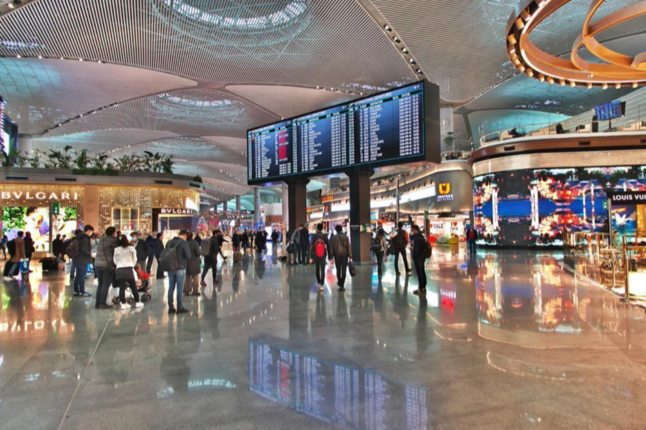 Travelers browse luxury shops and check flight information in the international departures hall at Istanbul Airport, Istanbul, Türkiye, March 20, 2021. (Adobe Stock Photo)
