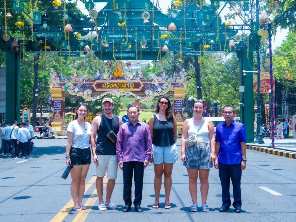 A group of officials and tourists gather at a festive khmer new year celebration.