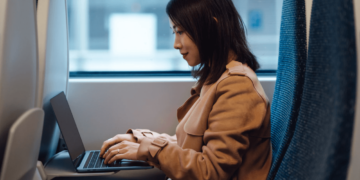 Image of lady on public transport on her laptop