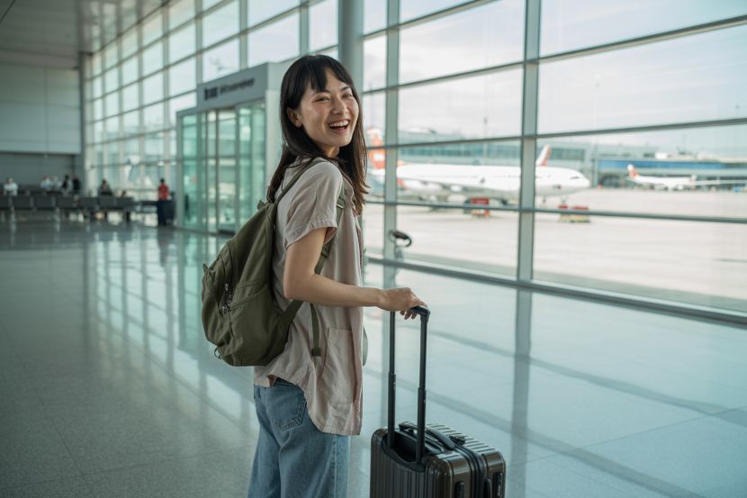 Happy traveler at airport with luggage for smooth border entry.