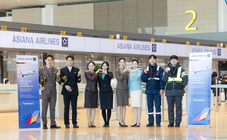 Pilots and cabin crew from Korean Air and Asiana Airlines pose at Incheon International Airport’s Terminal 2, celebrating Asiana