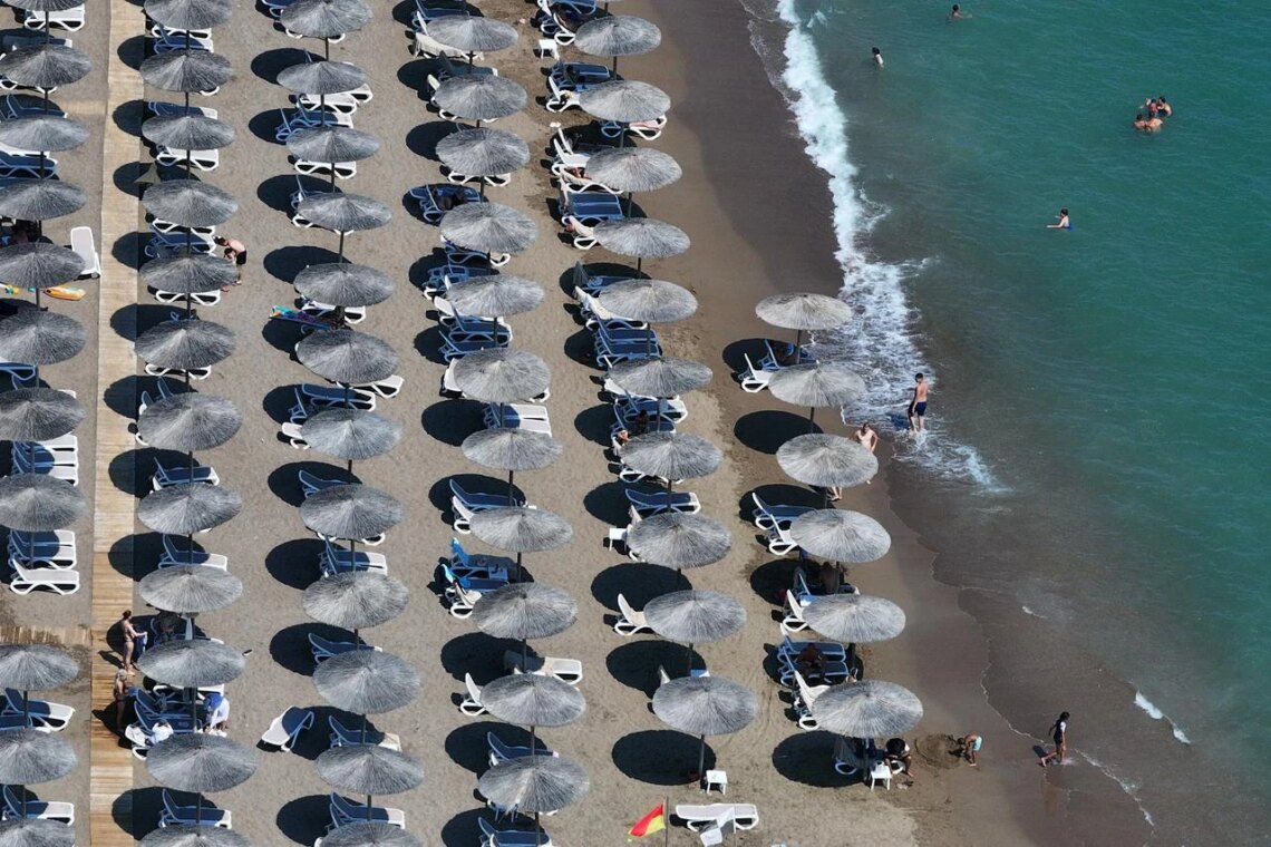 Aerial view of sandy beach with beach umbrellas on one of Antalya