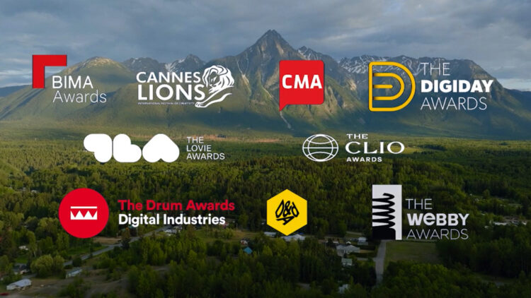Mountain landscape beneath a cloudy sky with logos for the BIMA Awards, Cannes Lions, CMA, The Digiday Awards, The Lovie Awards, The Clio Awards, The Drum Awards for Digital Industries, D&AD, and The Webby Awards.