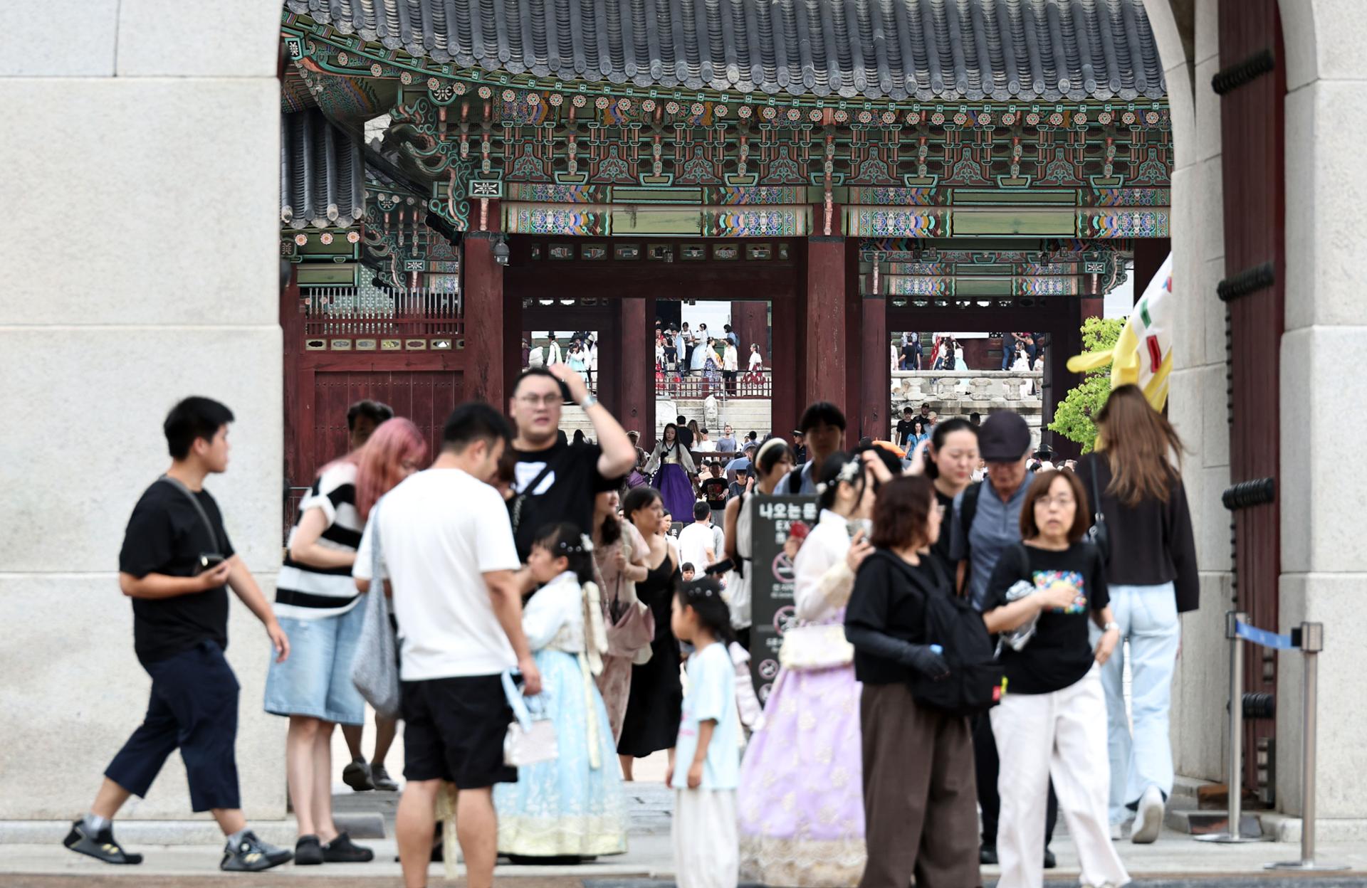 Foreign tourists explore the sights and energy of Gwanghwamun in Seoul, Aug. 17. Yonhap